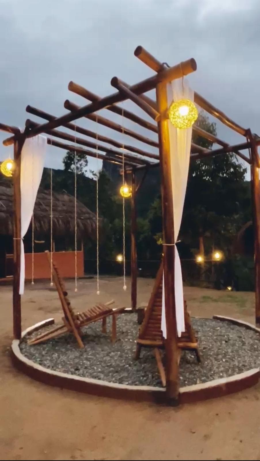 Lanterns glowing around the pergola at dusk