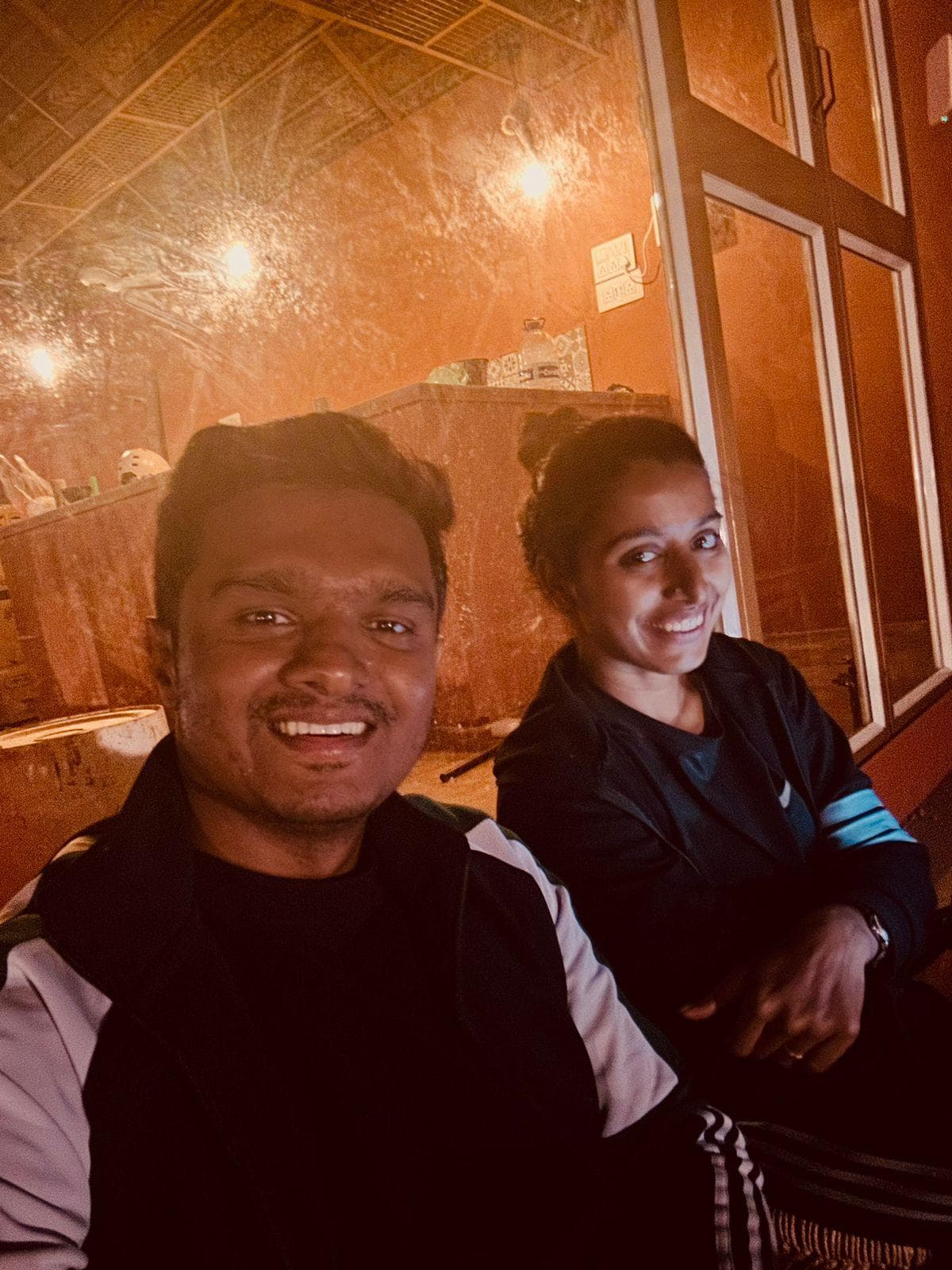 Two smiling guests in a warmly lit wooden room