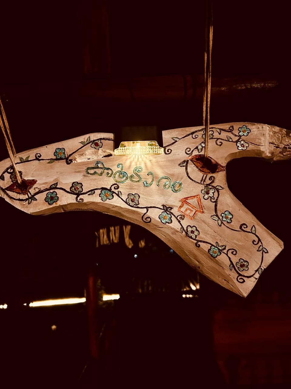 The hand-painted Koodaram sign glowing at night